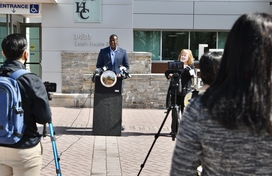 Calvin Ball standing at podium with crowd gathered