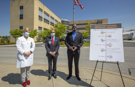 Calvin Ball and howard county general hospital officials standing in front of hospital