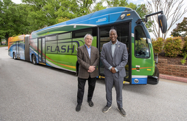 A photo of County Executive's Calvin Ball and Marc Elrich in front of a Flash Bus Rapid Transit Service bus.