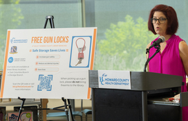 Health Officer Dr. Maura Rossman stands at a podium speaking at gun lock giveaway announcement