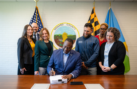 A photo of County Executive surrounded by staff members as he signs into place the Gateway Innovation District Master Plan.