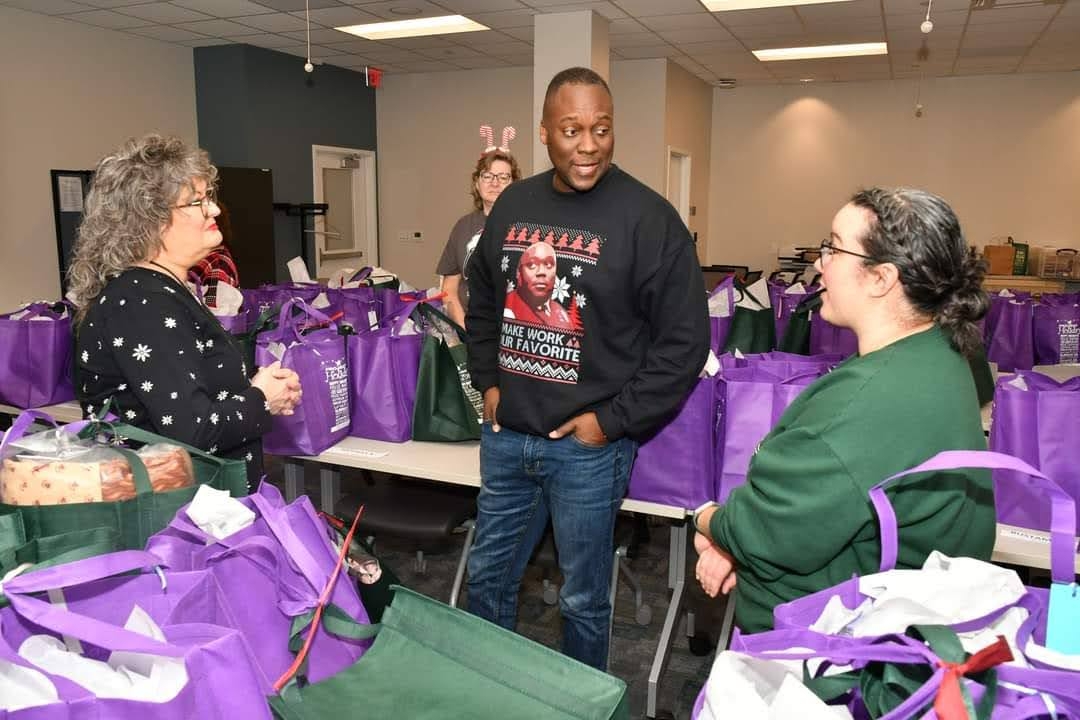 County Executive Dr. Calvin Ball listens to Project Holiday Coordinator, Morgan, talk about the initiative. 