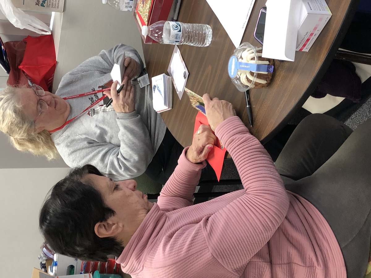 Project Holiday volunteers writing notes in holiday cards for the gift bags.