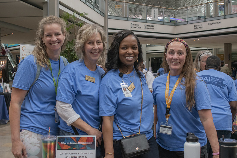 Four female staff member smiling in the blue event shirts