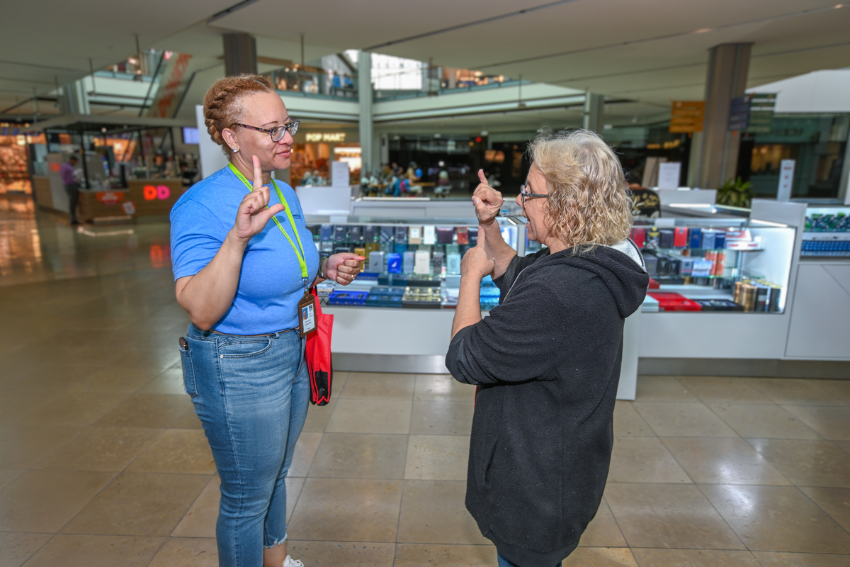 OAI female staff member signing with female showcase participant in the mall