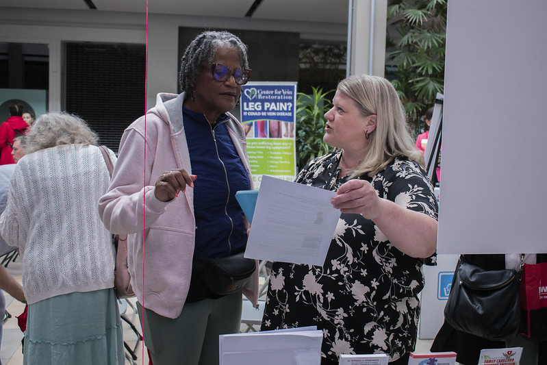 Female staff member talking to female participant at Loan Closet table