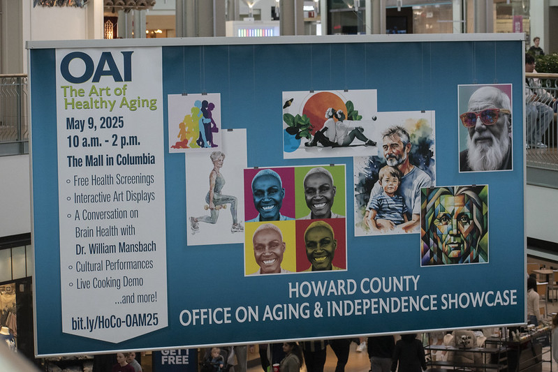 Photo of the OAI Showcase Banner at the mall in columbia. It has artistic photos of older adults and event info.