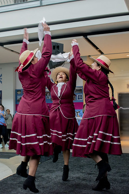 Peruvian Dance Group of 3 women in a circle dancing holding hands up.
