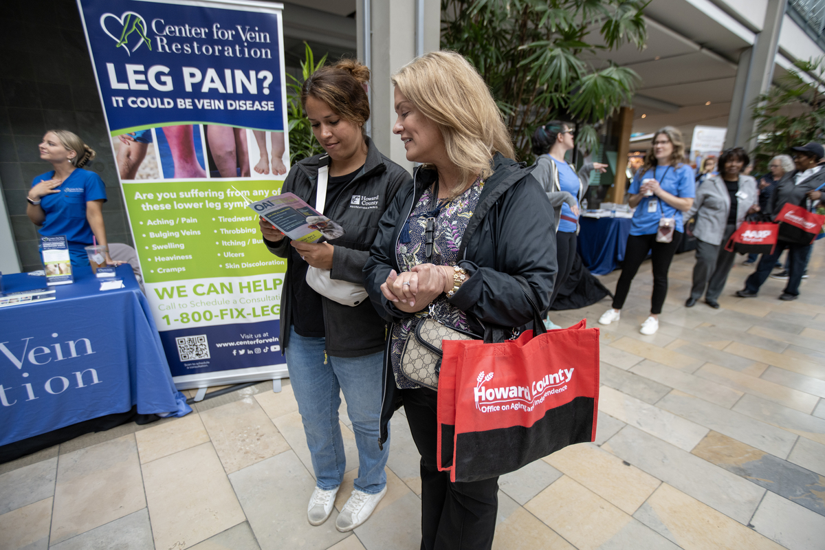 Two Rec and Park staff members reading the program for the event