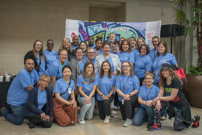 Group shot of about 20 staff members. mostly female all wearing blue event shirts.
