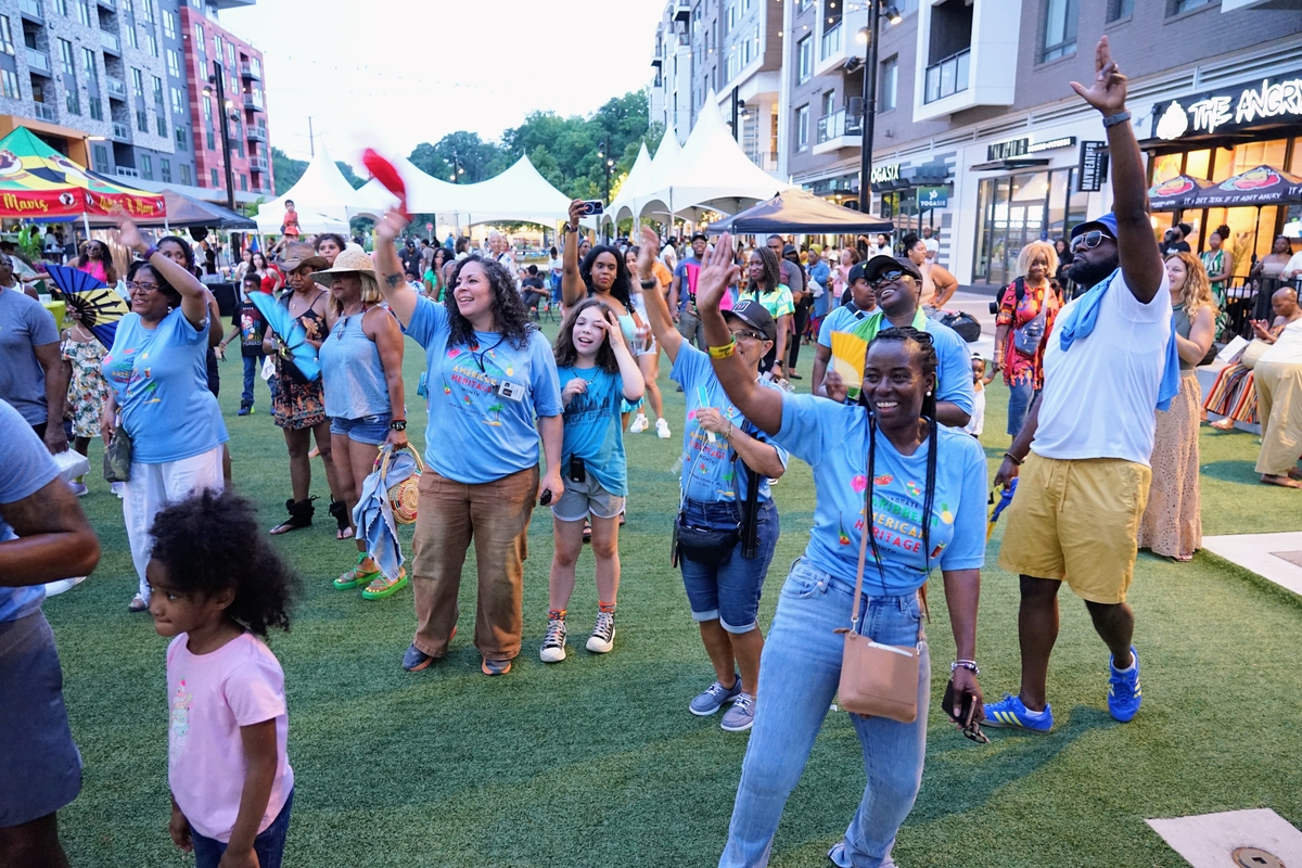 A group of people dance and wave flags
