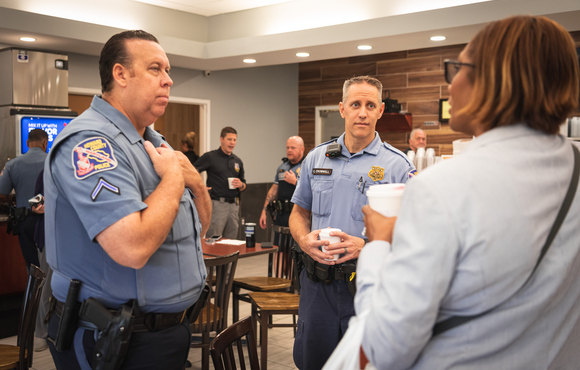 Two officers talk to a citizen at a Coffee with a Cop event