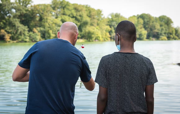 Officer and child fishing in lake