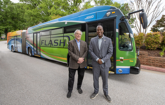 A photo of County Executive's Calvin Ball and Marc Elrich in front of a Flash Bus Rapid Transit Service bus.