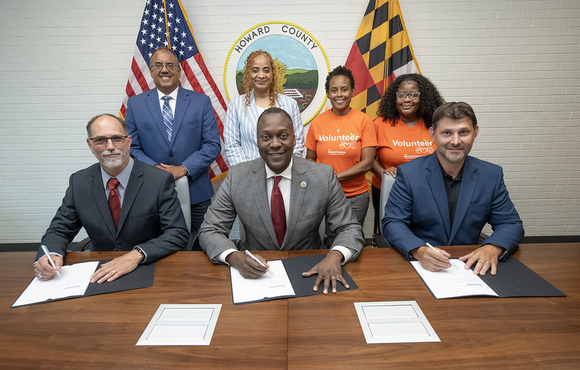 A photo of County Executive Calvin Ball with Lincoln College of Technology President Dr. James Martin and County Department of Recreation & Parks’ Director Nick Mooneyhan seated at a table and getting ready to sign a Memorandum of Understanding to formalize an innovative collaboration to expand Recreation & Parks’ Service & Skills Club’s service-learning workshops.