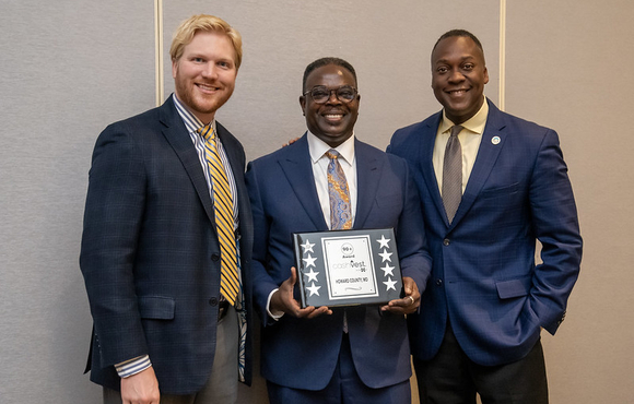 A photo of County Executive Calvin Ball, Department of Finance Director Rafiu Ighile, and three+one CEO Garrett Macdonald with the County's cashVest 90+ Award.