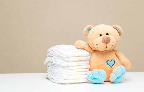 stack of diapers and a teddy bear