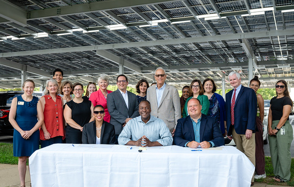 A photo of County Executive Calvin Ball seated at a table with Howard County Public School System Superintendent Bill Barnes and Howard Community College President Dr. Daria J. Willis getting ready to sign a memorandum of understanding to enhance collaboration between the County, HCPSS, and HCC and strengthen local action on climate and sustainability.