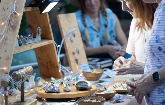 Older adults shopping at a craft fair table.