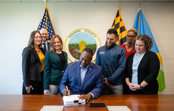 A photo of County Executive surrounded by staff members as he signs into place the Gateway Innovation District Master Plan.