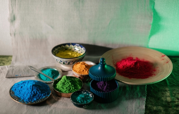 7 bowls filled with a variety of different powdered colors.