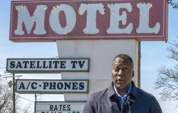 County Executive Calvin Ball standing at a podium in front of the Terrace Motel sign on US 1 speaking to press conference attendees about his support of Zoning Regulation Amendment 221.