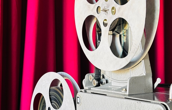 film projector in front of red curtain