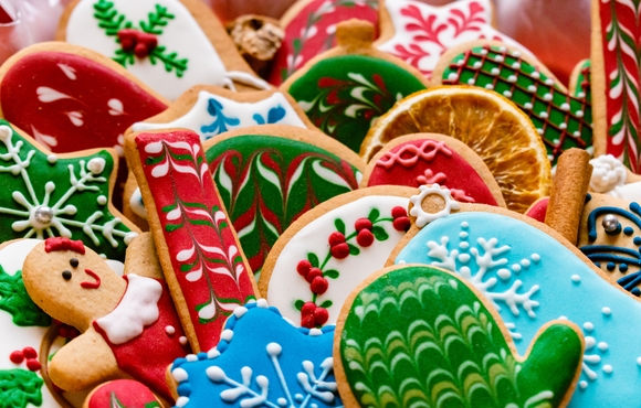 an assortment of holiday cookies in reds and greens and blues and whites shaped like gingerbread people, snowflakes, mittens, and candy canes