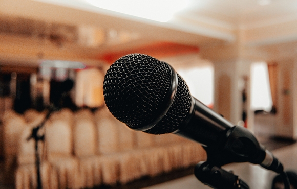 closeup of microphone in the foreground with empty seating in the background
