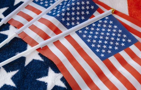three smaller American flags on top of a larger American flag