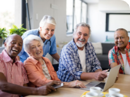 People gathered around a table looking at a computer