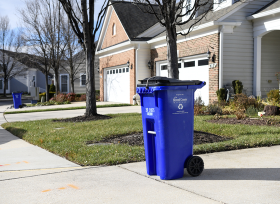 blue wheeled recycling cart at curb