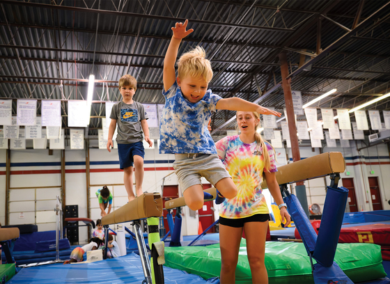 Child jumping off balance beam at Columbia Gymnastics