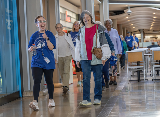 Group of older adults (primarily women) walking in the Mall of Columbia.
