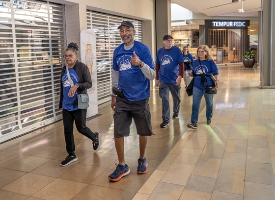 Group of 4 older adults walking in the mall.