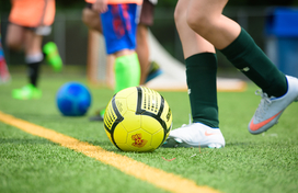 child kicking soccer ball