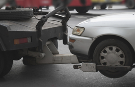 Photo of a tow truck towing a car.