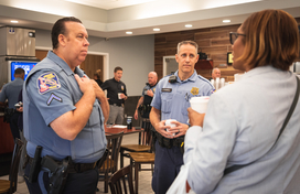 Two officers talk to a citizen at a Coffee with a Cop event