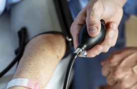 A photo of a doctor taking the blood pressure of a patient