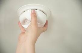 Person checks smoke alarm