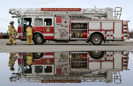 Firefighters standing next to a fire truck