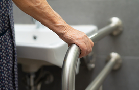 Older Adult holding accessibility bar in bathroom 
