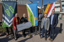 A photo of County Executive Calvin Ball holding up the new Howard County flag with flag designer and Ellicott City resident, Ms. Esen Paradiso.