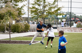 Officer plays football with young child
