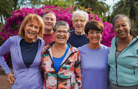 Group of 6 older adults including 2 men and 4 women smiling in fitness clothes.