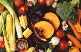 Assorted fresh fruits and vegetables on a black background