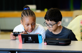 Two teens playing with a Nintendo Switch