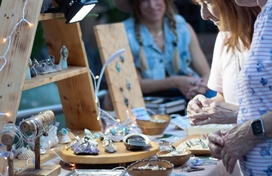 Older adults shopping at a craft fair table.