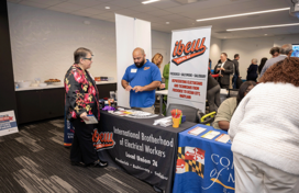 A member of the International Brotherhood of Electrical Workers speaking to a job fair attendee about the union.