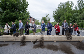 Calvin Ball and a group of people are holding a shovel with dirt in it